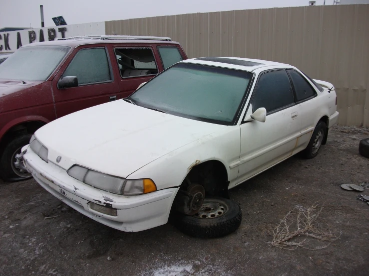 an old and new white car next to a red car