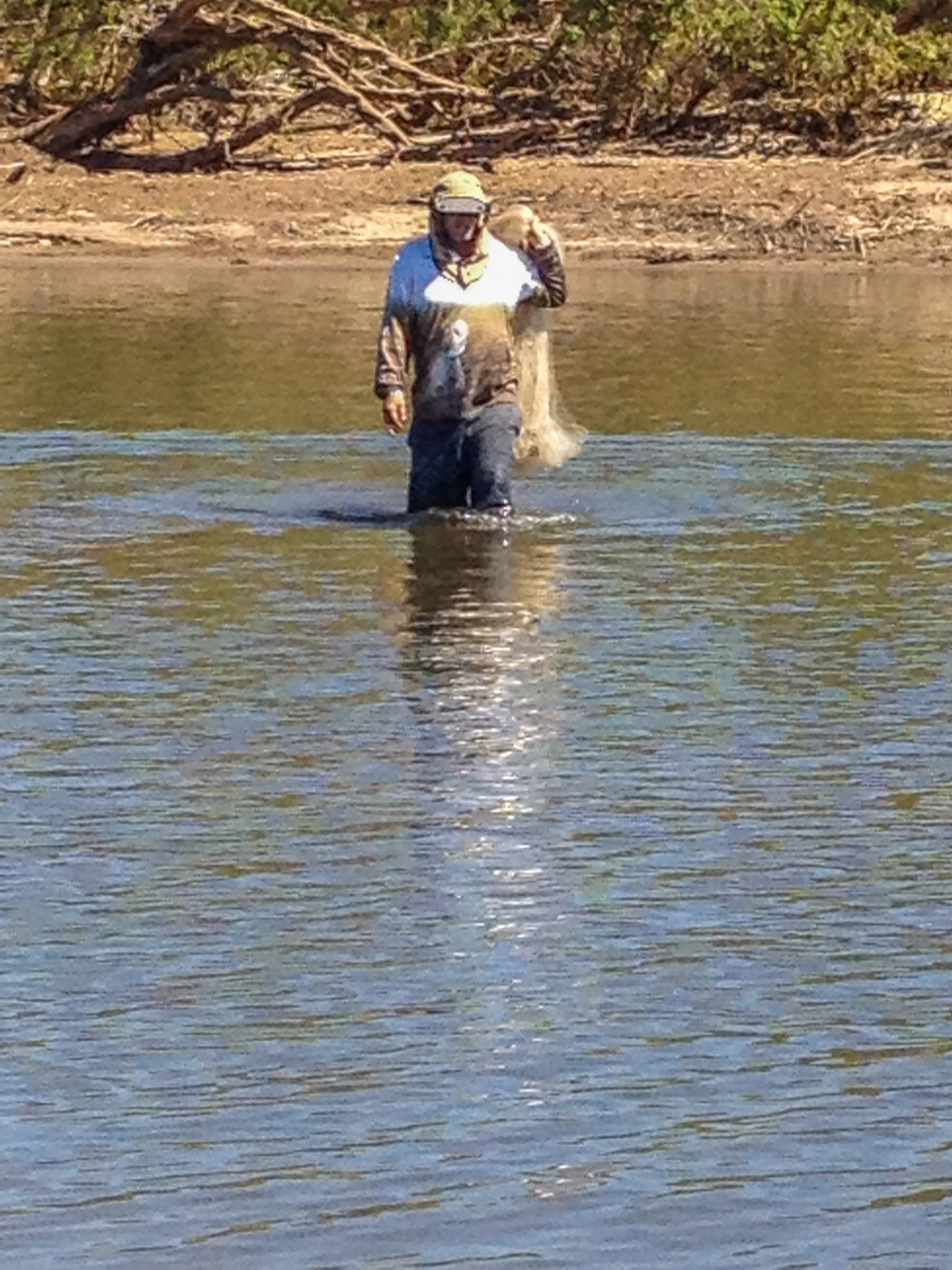 a man in a body of water holding a bird