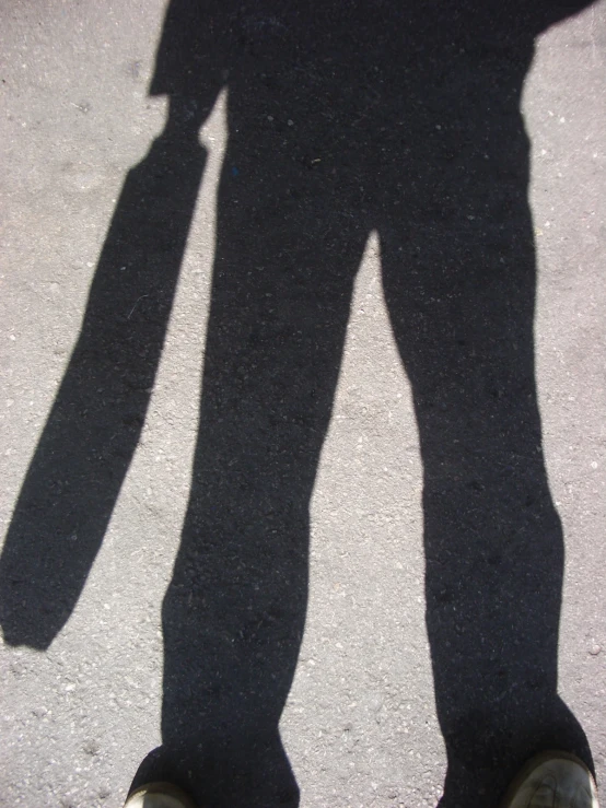 a shadow of a person with his shadow on the ground
