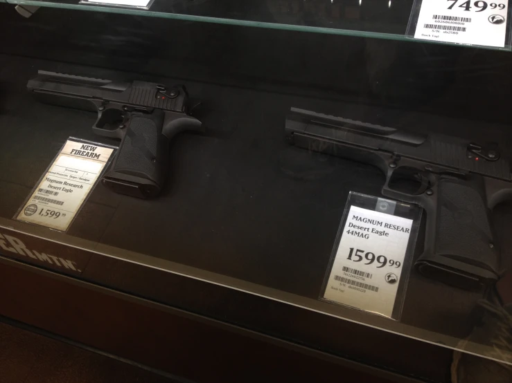 a display case with two guns, and two prices