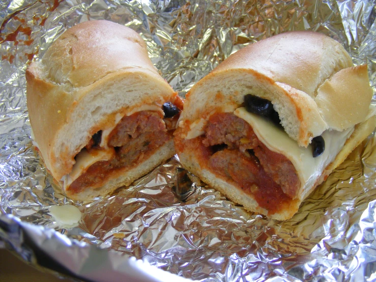 a meatball sub is sitting on some tin foil