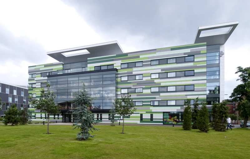 a multi - colored building is located on the grass next to a street