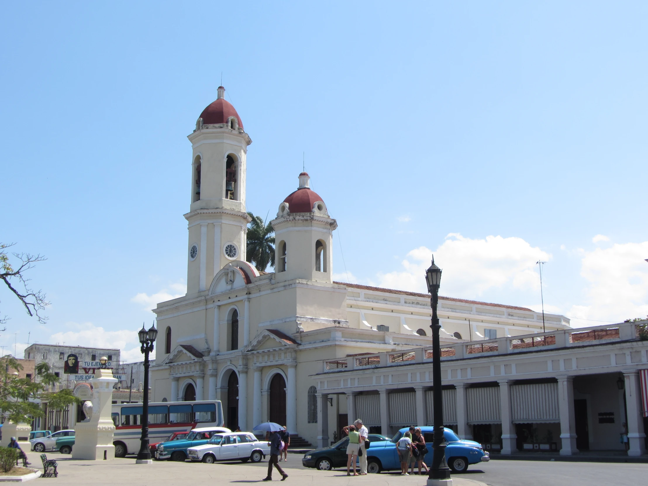 people walk along the road near an old church