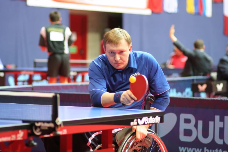 a man that is standing near some table tennis bats