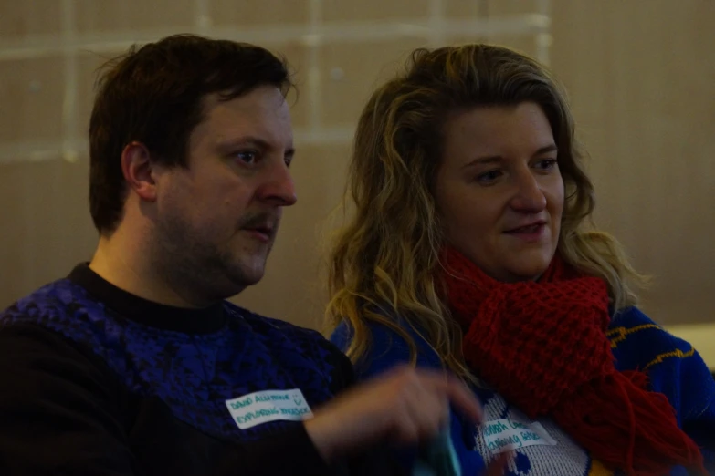 a man and woman sitting side by side in a room