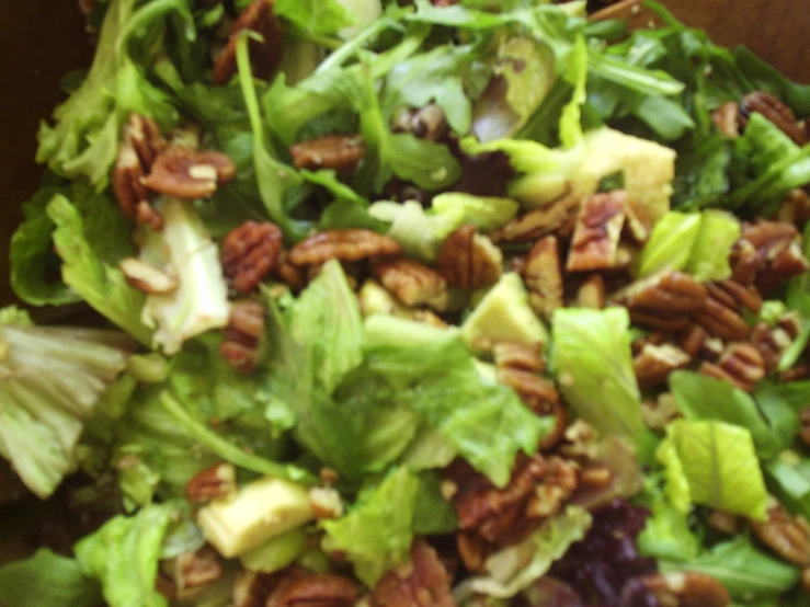 lettuce, carrots, and walnuts mixed together in a large salad