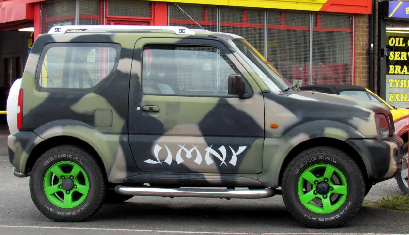 a small van with camouflage paint job parked on the street