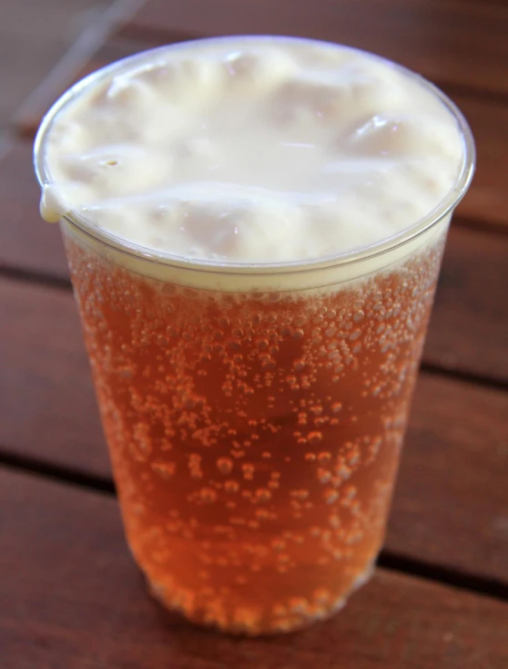 glass of light beer sitting on wooden table