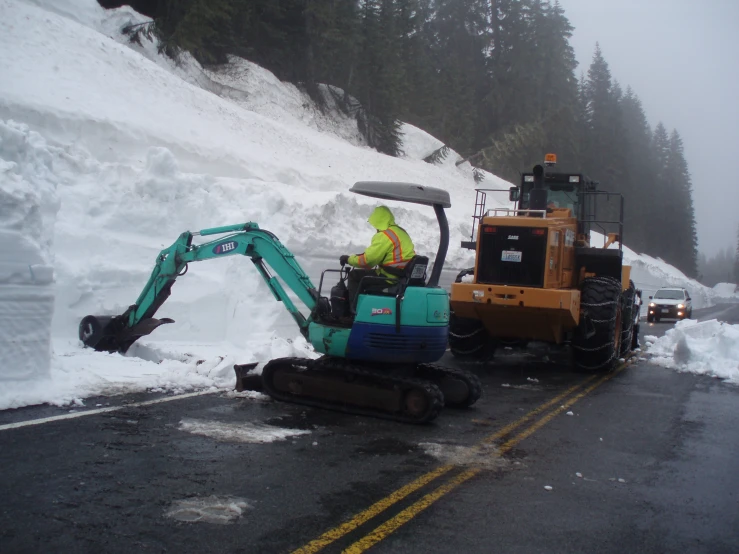 a road crew with a truck and loader clearing deep snow