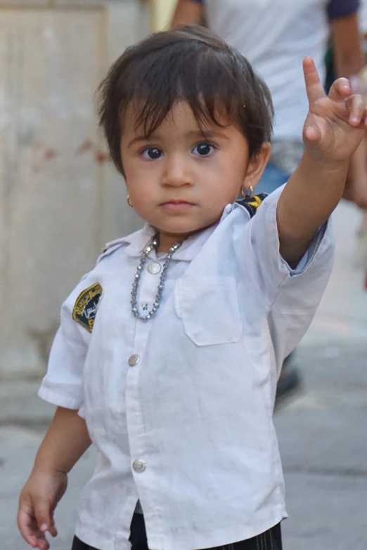 small  making the peace sign at a parade