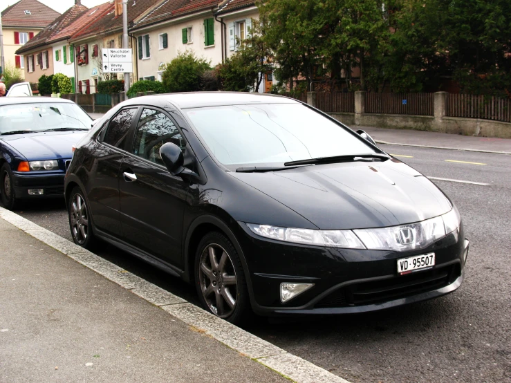 a black car is parked on the curb