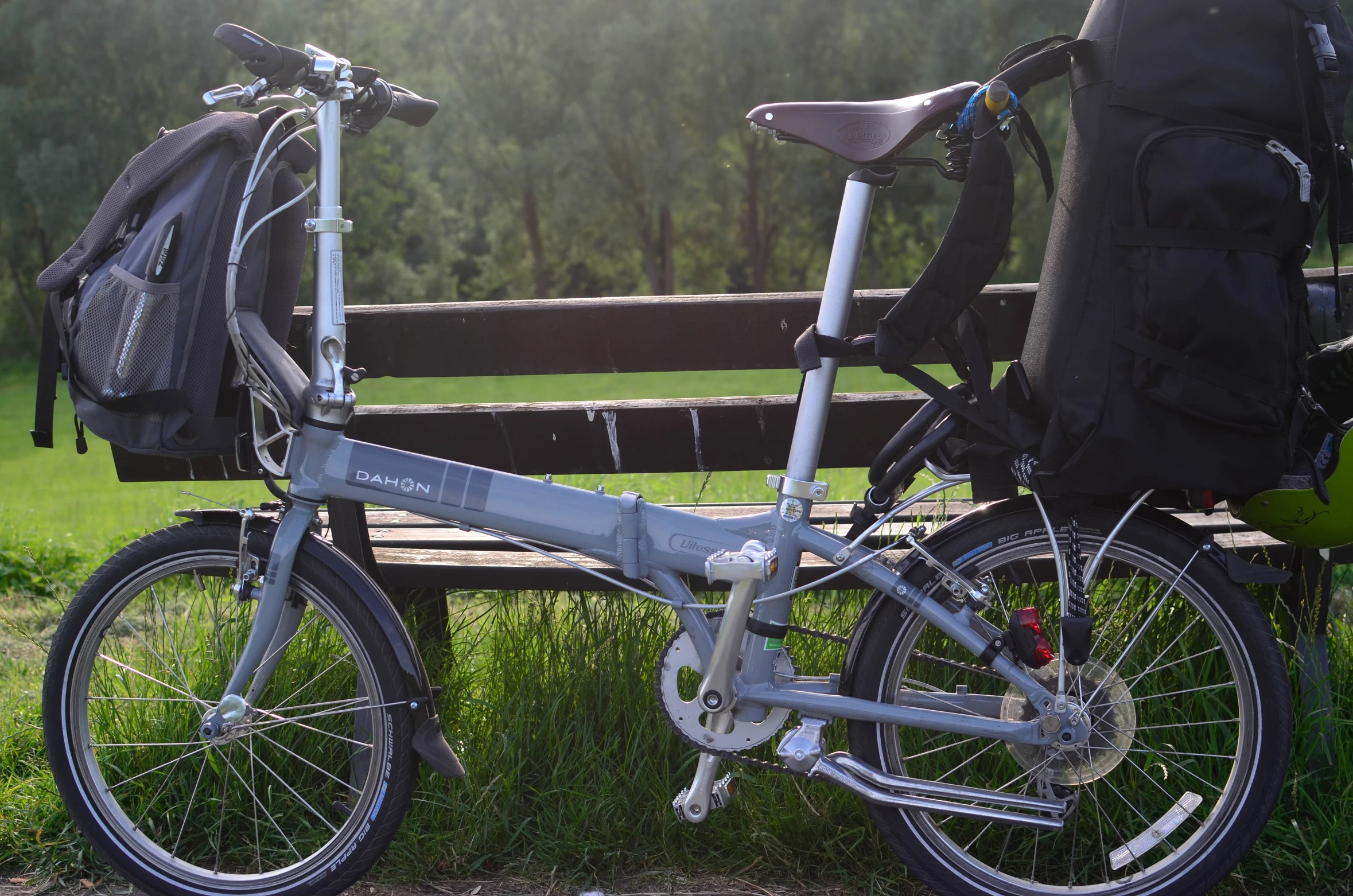 two bicycles are parked near a bench in the grass