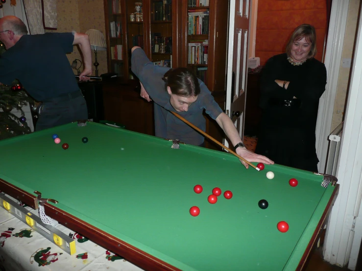 an image of a man playing pool with other people