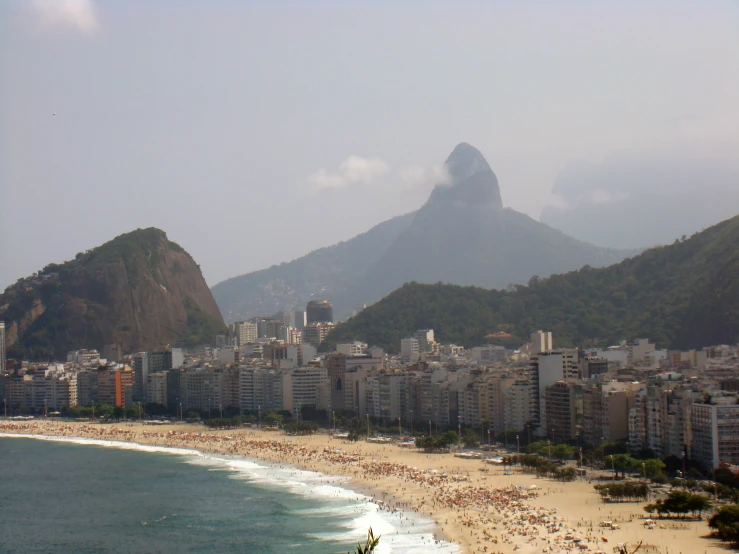 beach scene with mountains in the background and large ocean front