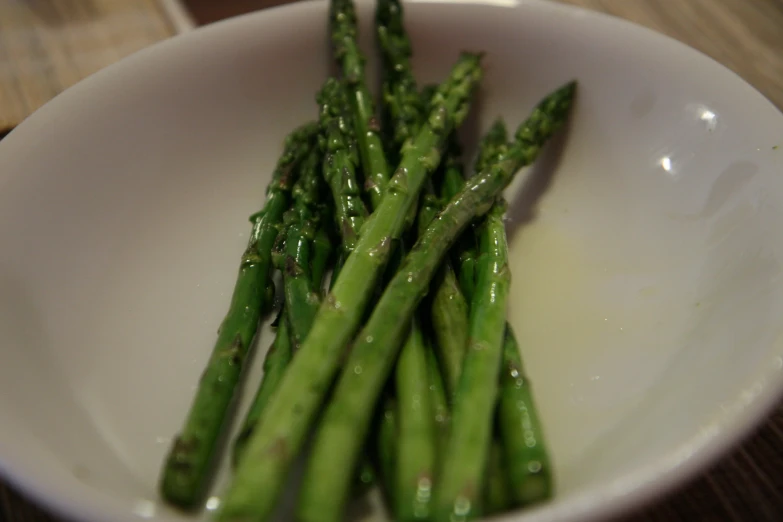 the plate is holding green asparagus on the table