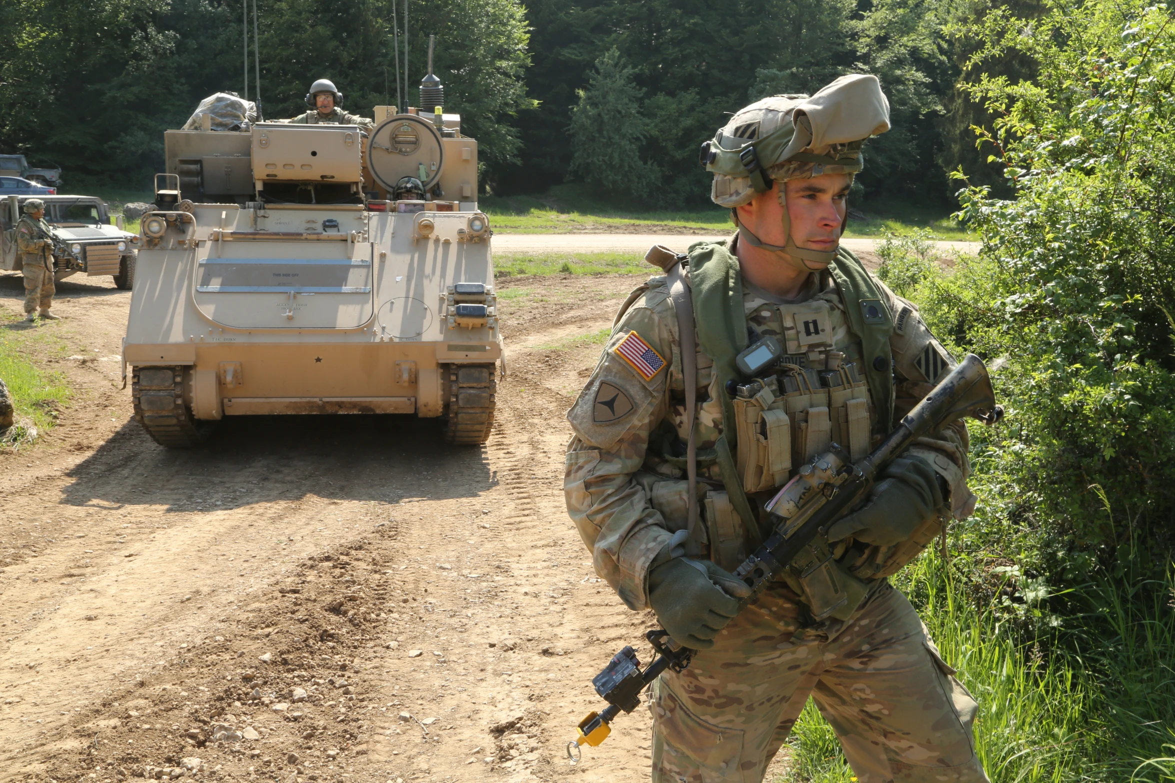 an army soldier is standing outside next to a vehicle