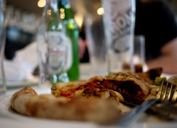 the plate is full of a thick meat, cheese and vegetable sandwich