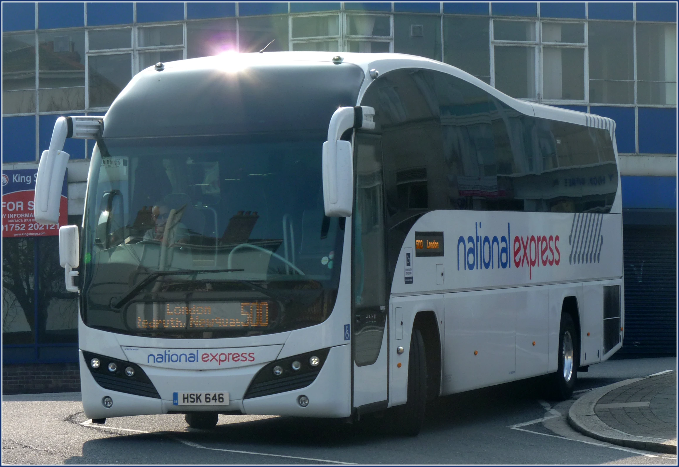 a white bus is parked on the street