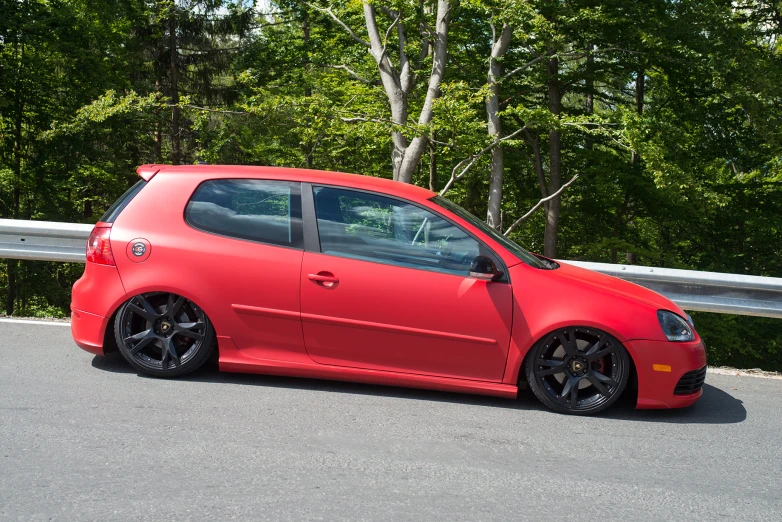 a red car parked near a wooden fence