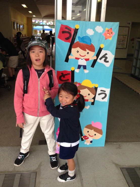 two children who are standing in front of a sign