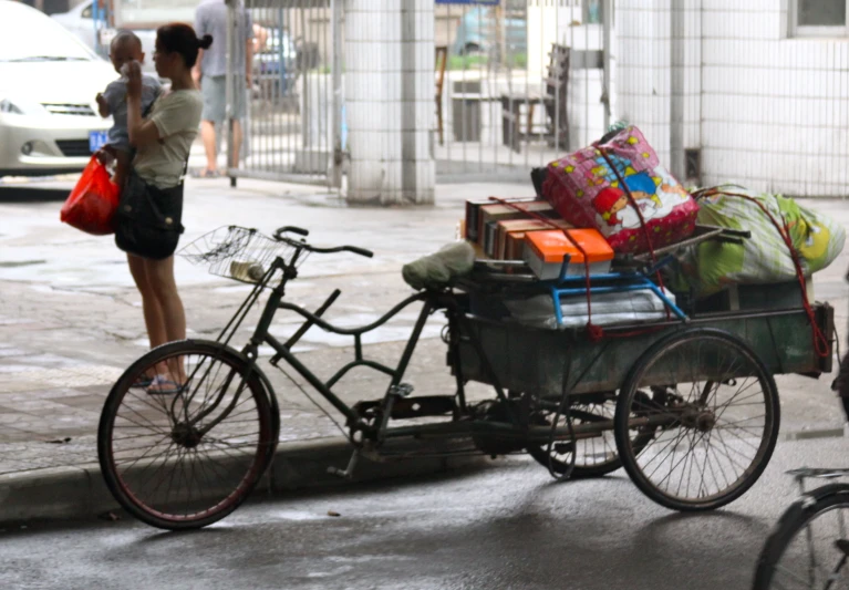 a women is hing a rickshaw down the street