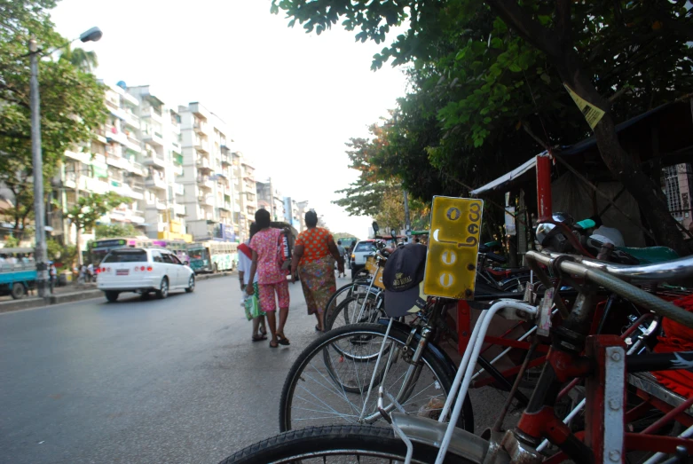 several people walking down a city street on bicycles