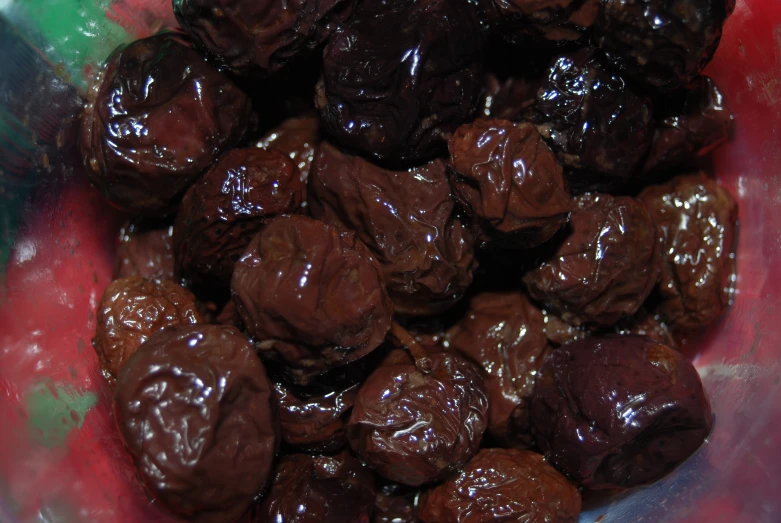 a close up of a chocolate doughnut in a red plastic container