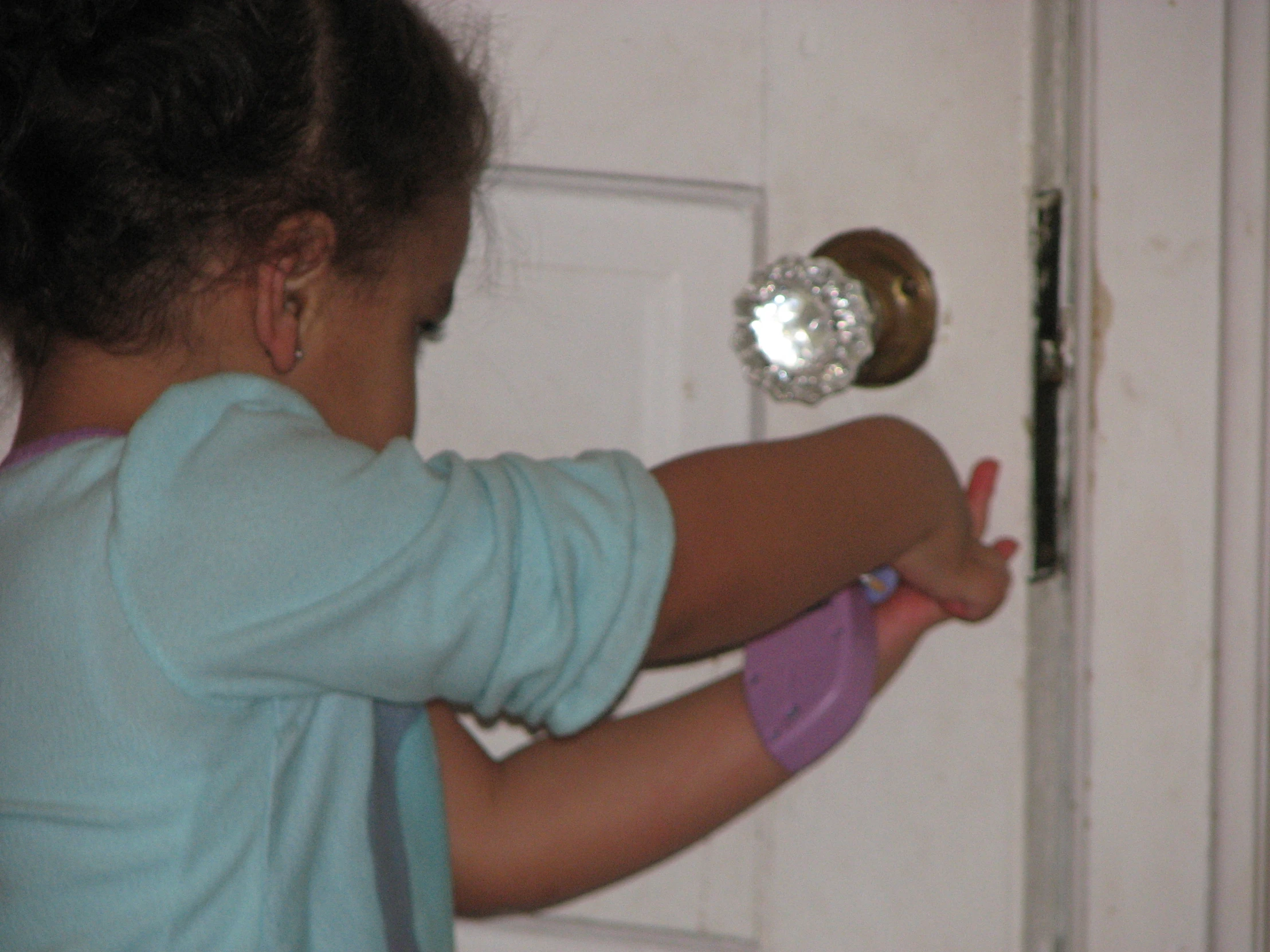 a little girl opening the door of a house