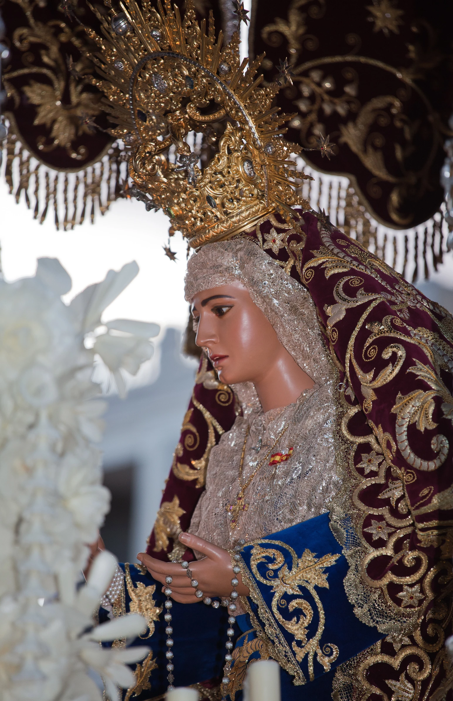 a statue made from paper, wearing traditional garb and jewelry