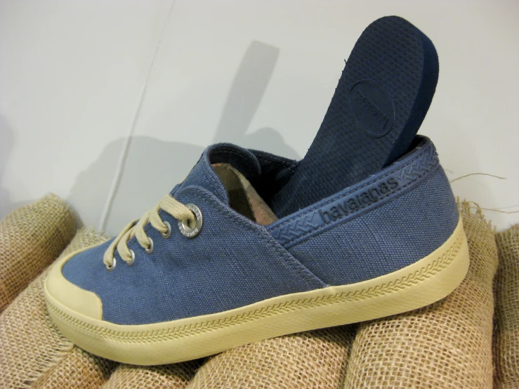 blue sneakers sit on a tan cloth