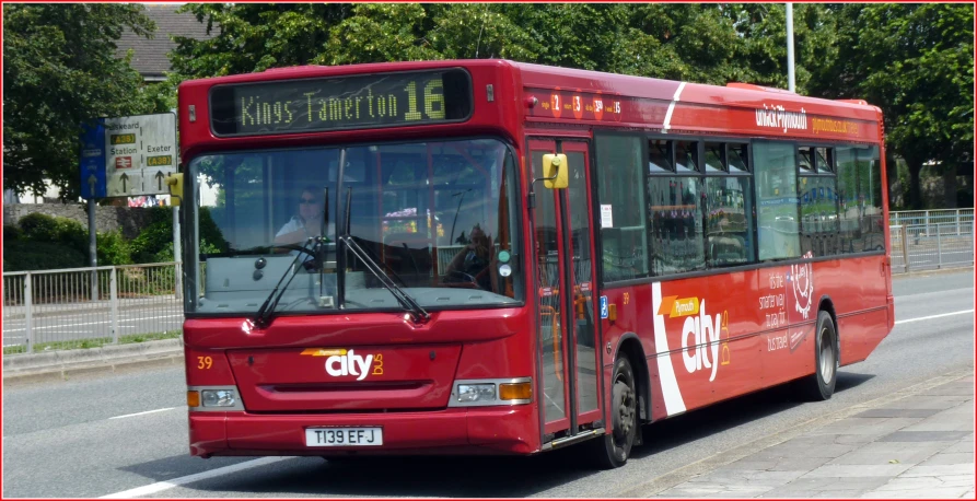 a red passenger bus traveling down the road