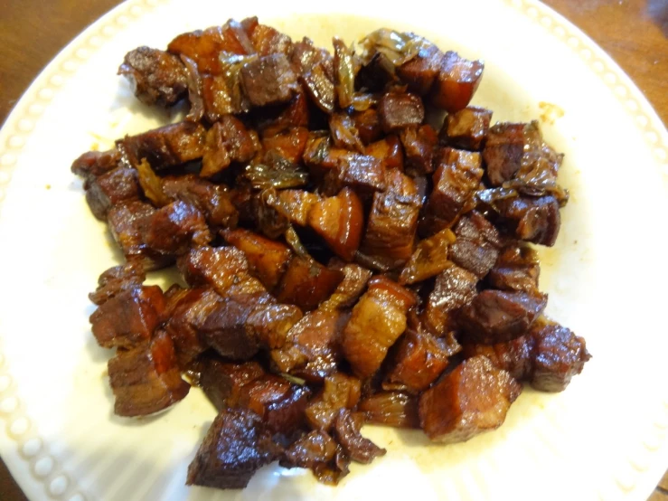 a plate full of cooked meat on top of a wooden table