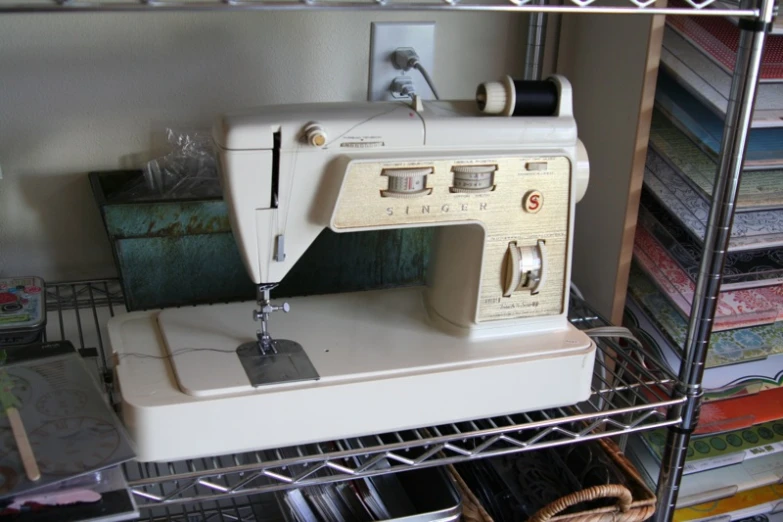 an old white sewing machine sits on a shelf