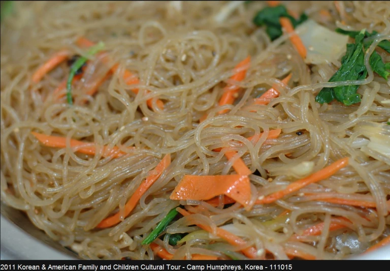 a picture of some noodles and carrots in a white bowl