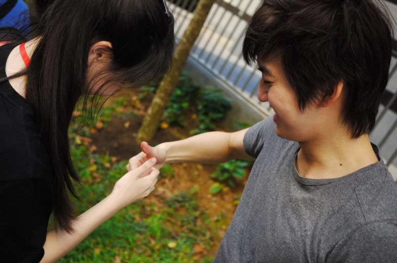 a young woman touching the other hand with a girl nearby