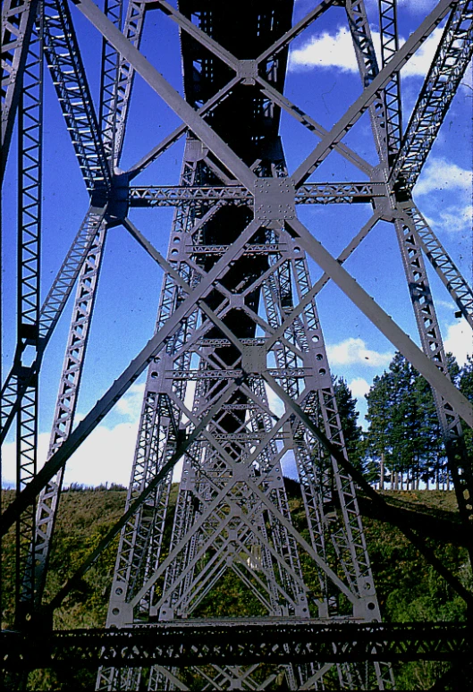 the bottom of a large metal tower on top of a hill