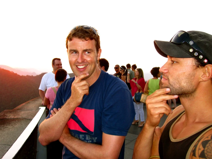 two men standing in front of an ocean