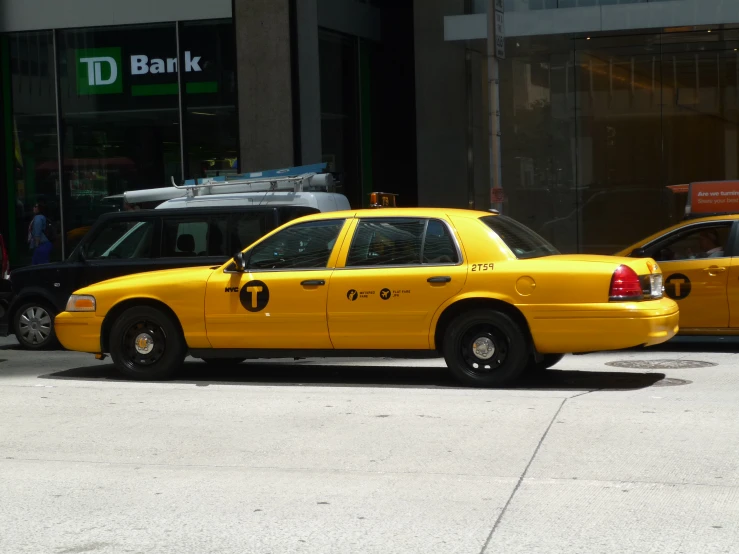 two yellow taxis stopped side by side in the street