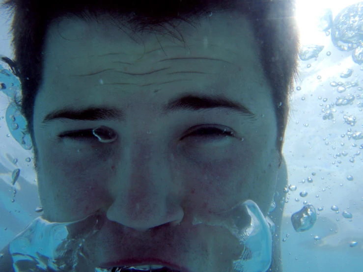 man floating under water wearing a ring for a nose ring