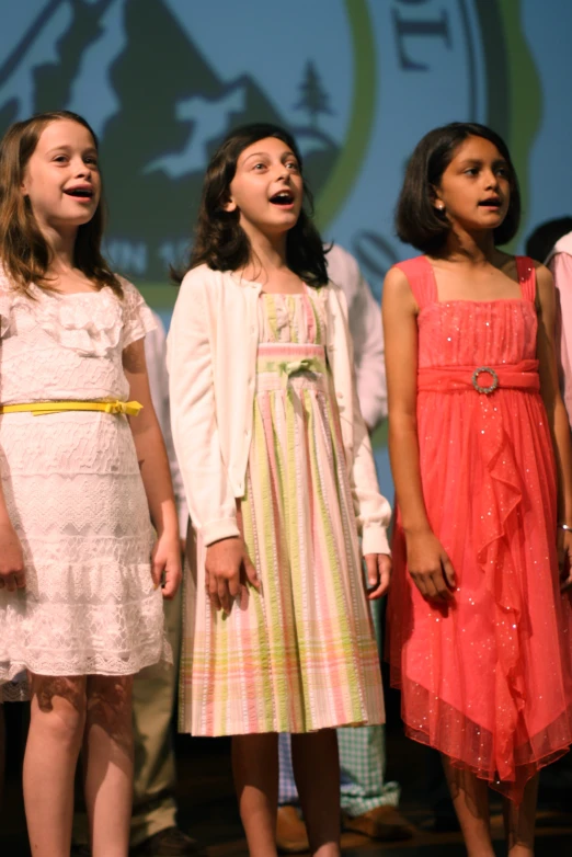 a group of s singing on a stage