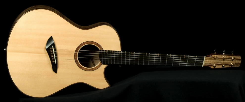 a wooden acoustic guitar sitting on a black cloth