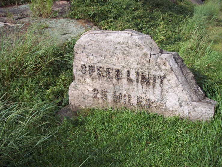 there is a large rock with a written message in the rocks