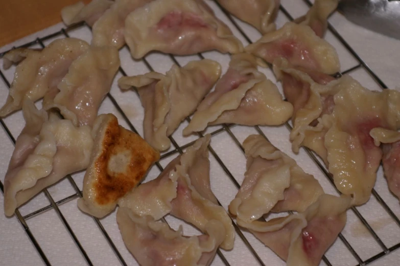 an assortment of dumplings sit on a grill