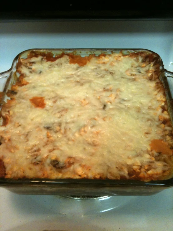 a baking dish that has meat and grated cheese in it