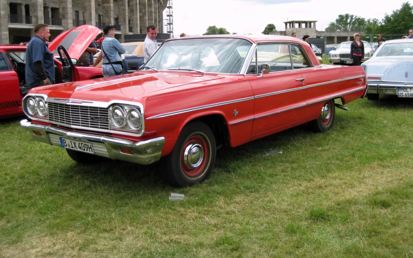 many cars parked outside on the grass at a car show