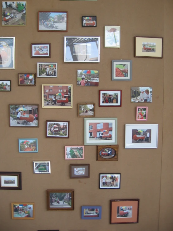 a cork board wall display with various framed pictures