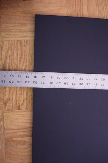 a ruler is measuring a piece of black paper