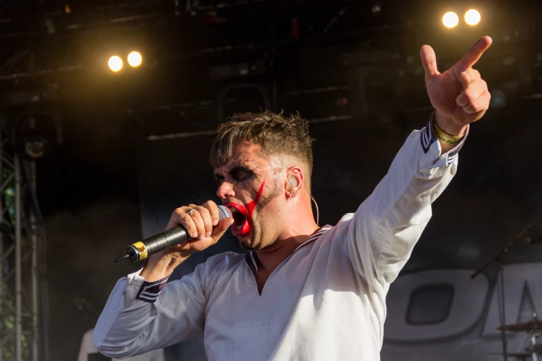 a man standing up and raising his hand to the sky