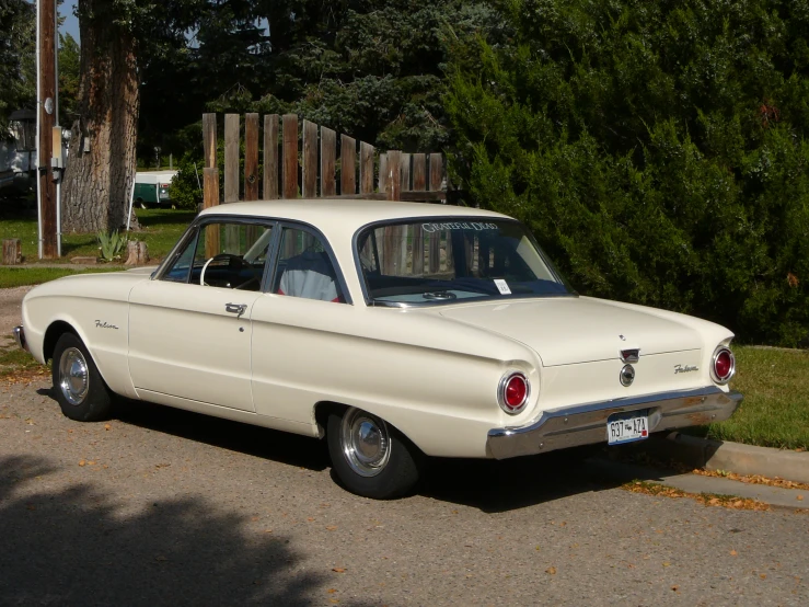 the old car is parked by the tree