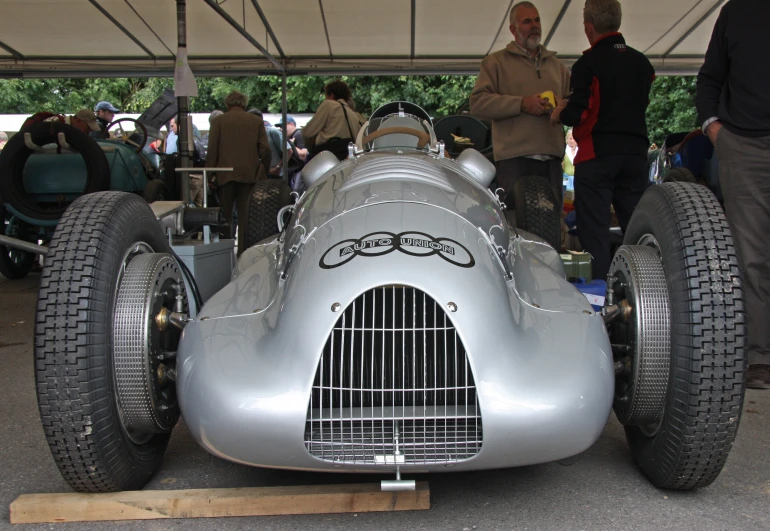 this silver race car has a grilled air vent